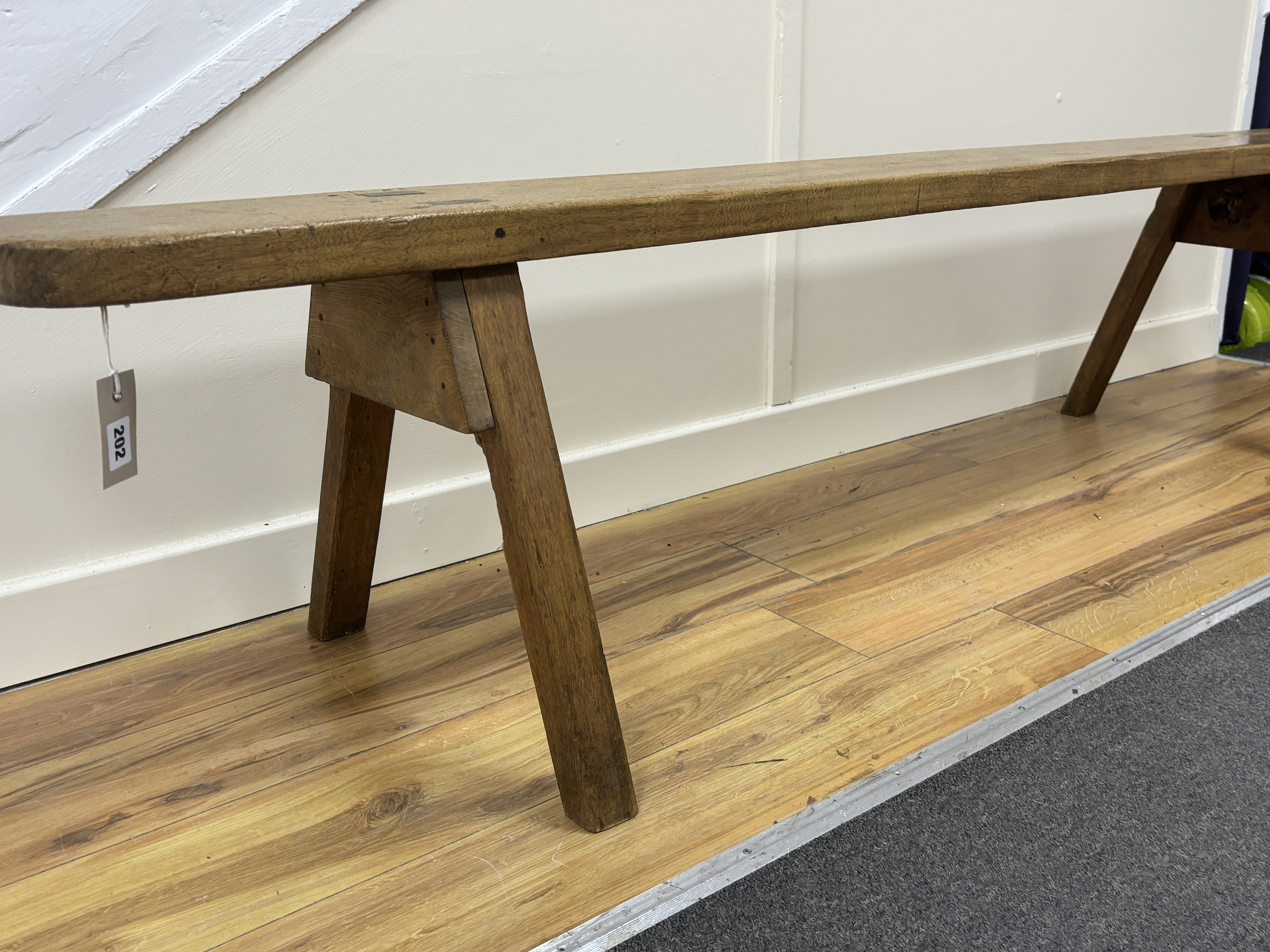 A 19th century French fruitwood bench seat, length 197cm, height 45cm